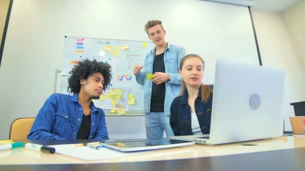 Tres jóvenes trabajan en empresas por el proyecto — Vídeos de Stock