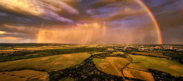 Foto aerea panoramica di un arcobaleno drammatico sul paesaggio europeo. Grande arcobaleno in tarda serata su città e colline nel paesaggio agricolo. Arcobaleno sopra Litovelske pomoravi riserva naturale nazionale . — Foto Stock