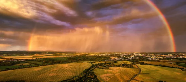 Panoramic, aerial photo of dramatic rainbow over european landscape. Large late evening rainbow over city and hills in agricultural landscape. Rainbow over Litovelske pomoravi national nature reserve.