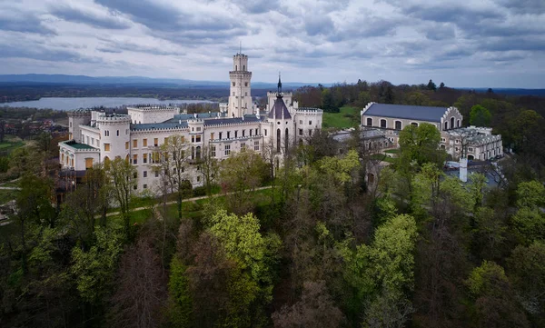 Vista aérea del castillo checo más hermoso y de cuento de hadas, el castillo neogótico Huboka.Famoso, como el castillo de Wndsor situado en un gran parque inglés. Vista desde el lado del parque contra el cielo dramático. Checo paisaje . — Foto de Stock