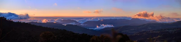 Panoramisch zicht op de Cerro de la Muerte Costa Rica met een vulkaan in de wolken, verlicht door de ondergaande zon. Berg de landascape. Nationaal Park Los Quetzales natuurreservaat. Costa Rica. — Stockfoto