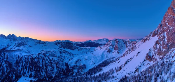 ペール マルティーノの山々に覆われた雪に覆われた空中でカラフルなパノラマの冬の景色 パソロールビュー 夕方の山の景色 オレンジと濃い青の空 ドロマイト マルティーノ カストロッツァ イタリア — ストック写真