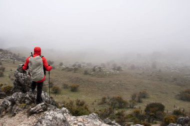 Gri bir günde dağın kapısı içinde uzun yürüyüşe çıkan kimse