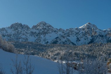 Güneş, kar yağdıktan sonra dağ köyünü aydınlatıyor.