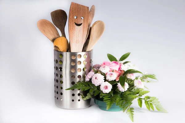 Деревянные кухонные принадлежности с улыбкой и красивым цветком — стоковое фото