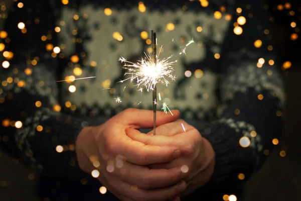 Mann hält bunte Weihnachts-Wunderkerze in der Hand. — Stockfoto