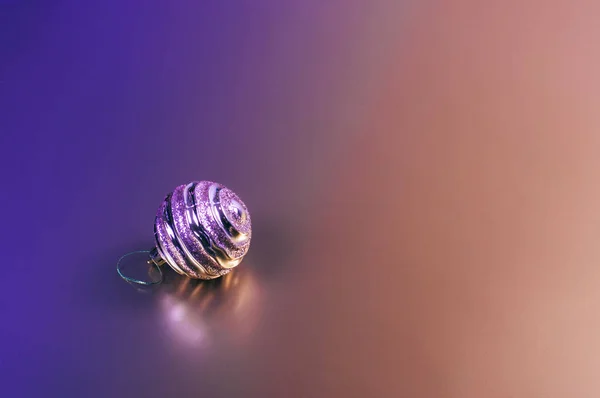 İki renkli arka planda parlak bir Noel dekoratif balosu.