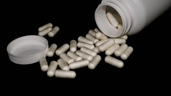 Таблетки Черном Фоне Витамины Разбросаны Ровном Фоне Большие Белые Капсулы — стоковое фото