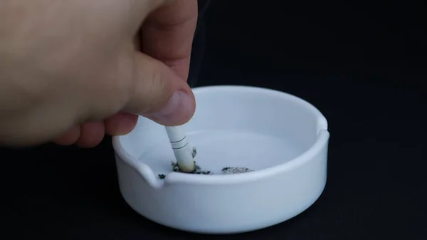 Oltsatok Egy Cigarettát Hamutartóban Fekete Háttérrel — Stock Fotó
