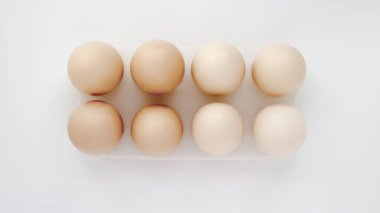 Beyaz arka planda tepside yumurta yumurtalarının üst görüntüsü.