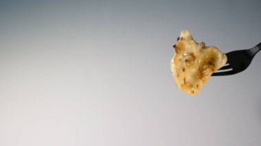 Beyaz bir arka planda yenilebilir bir çatalda hamur tatlısı..