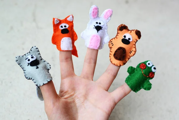 Hand wearing 5 finger puppets