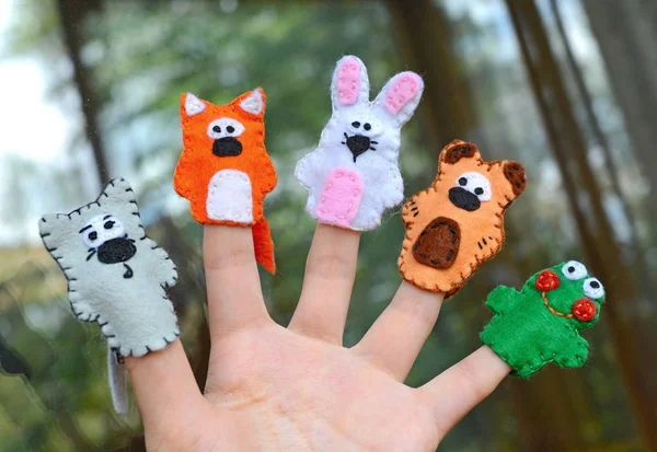 Hand wearing 5 finger puppets; wolf, fox, rabbit, bear, frog