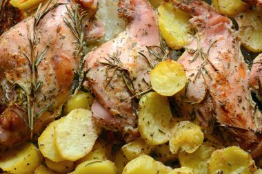 Oven Baked rabbit legs with potatoes and rosemary clipart