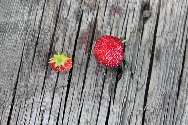 Zwei reife rote Erdbeeren auf einem alten Tisch — Stockfoto
