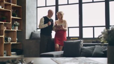 Tablet kullanma şık bir oturma odasında modern yaşlı zengin Çift