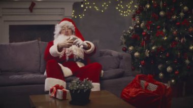 Genç adam giyim Noel Baba yapma video konferans araması tarafından cep telefonu