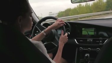 Kadın sürücü otoyolda hareket ediyor. Güzel bir kadın direksiyonda.