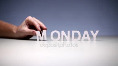 Tablo arka plan üzerinde erkek el kompozisyon kelime Pazartesi. Hafta içinde ilk iş günü