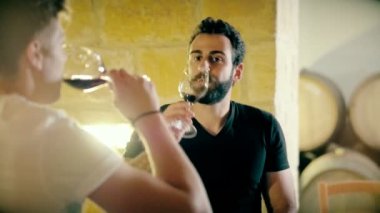 Adam şarap tüccarı ve kiler odası varil arka plan üzerinde kırmızı şarap tatma sommelier