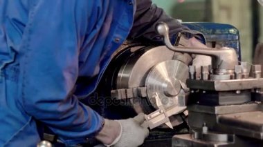 Torna Torna çalışma sırasında ayrıntı ölçmek için kumpas kullanarak çalışan