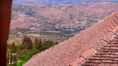 Vadi yeşil tepeler ve ağaçlar arasında köyde uzun boylu döşenmiş çatı üzerinden Panorama