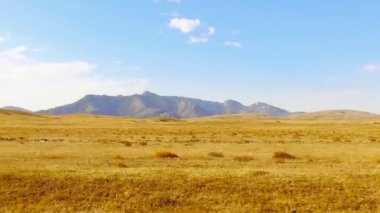 Çöl alanları ve tepeler ile tozlu kırsal yolda araç hareket penceresinden görüntülemek