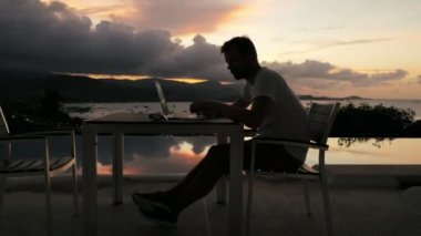 Dizüstü bilgisayarda çalışarak ve cep telefonuyla konuşan adam serbest meslek