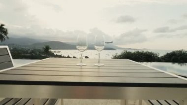 Ahşap masa ve gökyüzünde uçan uçak üzerinde duran iki boş bardak