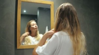 Güzel kadın sarışın açık banyo aynada penye