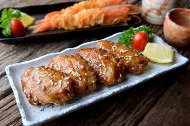 Kızarmış tavuk kanadı Japon tebasaki tarzı baharatlı sos ile.