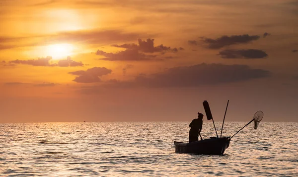Silhouet van visser met warme en zonsondergang tijd. — Stockfoto