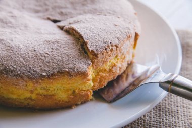 Beyaz ahşap zemin üzerinde beyaz tabakta pastadan bir dilim ev yapımı elma pasta bisküvi yakın çekim 