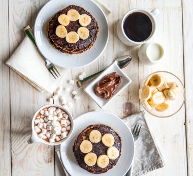 Yulaf krep muz, nutella, tatlım, kahve ve süt ve kakao ile beyaz ahşap zemin üzerinde hatmi ile çift için kahvaltı dahildir