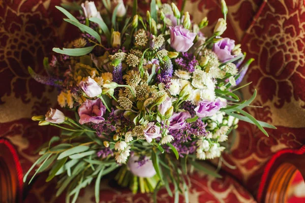 Beau bouquet de mariage violet sur fauteuil luxueux — Photo