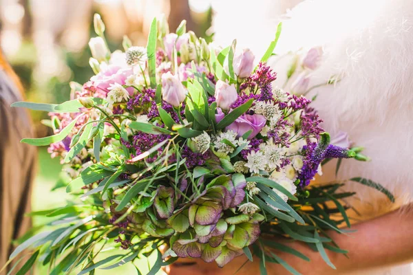 Beau bouquet de mariage violet entre les mains de la mariée — Photo