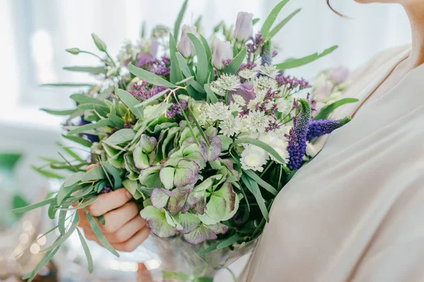 Beau bouquet de mariage violet entre les mains de la mariée — Photo