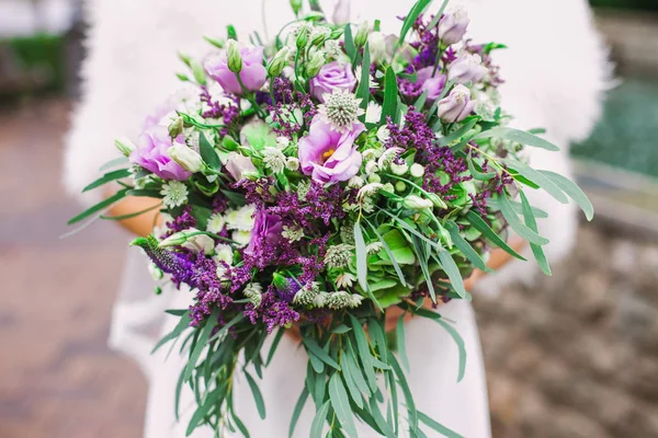 Beau bouquet de mariage violet entre les mains de la mariée — Photo