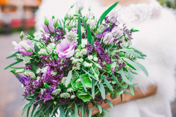Vackert lila bröllop bukett i brudens händer — Stockfoto