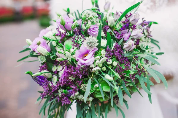 Beau bouquet de mariage violet entre les mains de la mariée — Photo