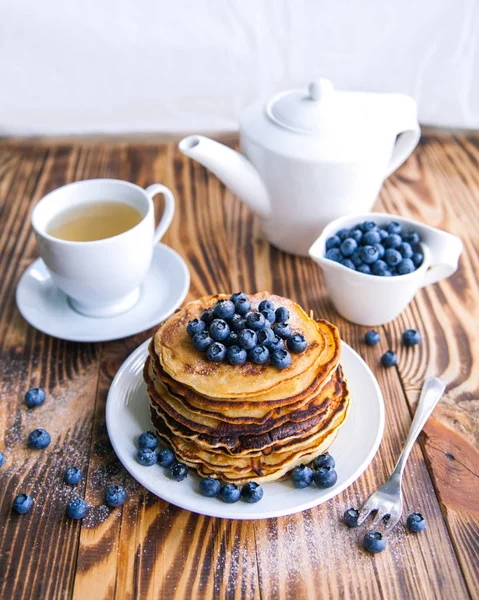 Yaban mersini, bataklık whortleberry, yeşil çay, yaban mersini ve çaydanlık kahverengi ahşap zemin üzerinde kupa ile sağlıklı kahvaltı krep 