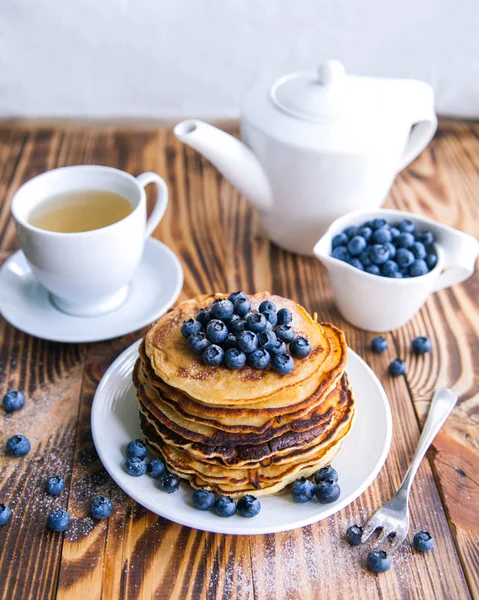 Yaban mersini, bataklık whortleberry, yeşil çay, yaban mersini ve çaydanlık kahverengi ahşap zemin üzerinde kupa ile sağlıklı kahvaltı krep 
