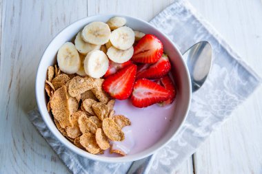 Sağlıklı kahvaltı dahil mısır gevreği ve oatflakes, yoğurt, muz ve çilek