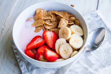 Sağlıklı kahvaltı dahil mısır gevreği ve oatflakes, yoğurt, muz ve çilek