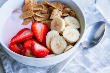 Sağlıklı kahvaltı dahil mısır gevreği ve oatflakes, yoğurt, muz ve çilek