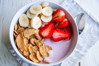 Sağlıklı kahvaltı dahil mısır gevreği ve oatflakes, yoğurt, muz ve çilek