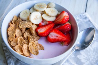 Sağlıklı kahvaltı dahil mısır gevreği ve oatflakes, yoğurt, muz ve çilek