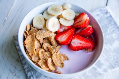 Sağlıklı kahvaltı dahil mısır gevreği ve oatflakes, yoğurt, muz ve çilek