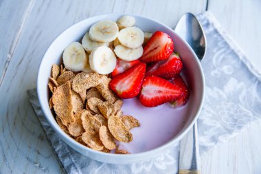 Sağlıklı kahvaltı dahil mısır gevreği ve oatflakes, yoğurt, muz ve çilek