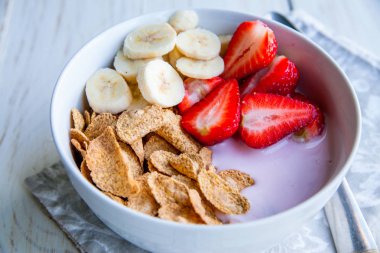 Sağlıklı kahvaltı dahil mısır gevreği ve oatflakes, yoğurt, muz ve çilek